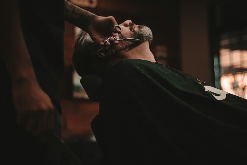 Cliente recostado na cadeira durante a barba
